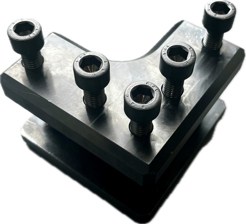 Metallkomponendi lähivõte kuuskantpoldidega, mõeldud masinates kasutamiseks, esitledes pinna ja detailide omadusi.