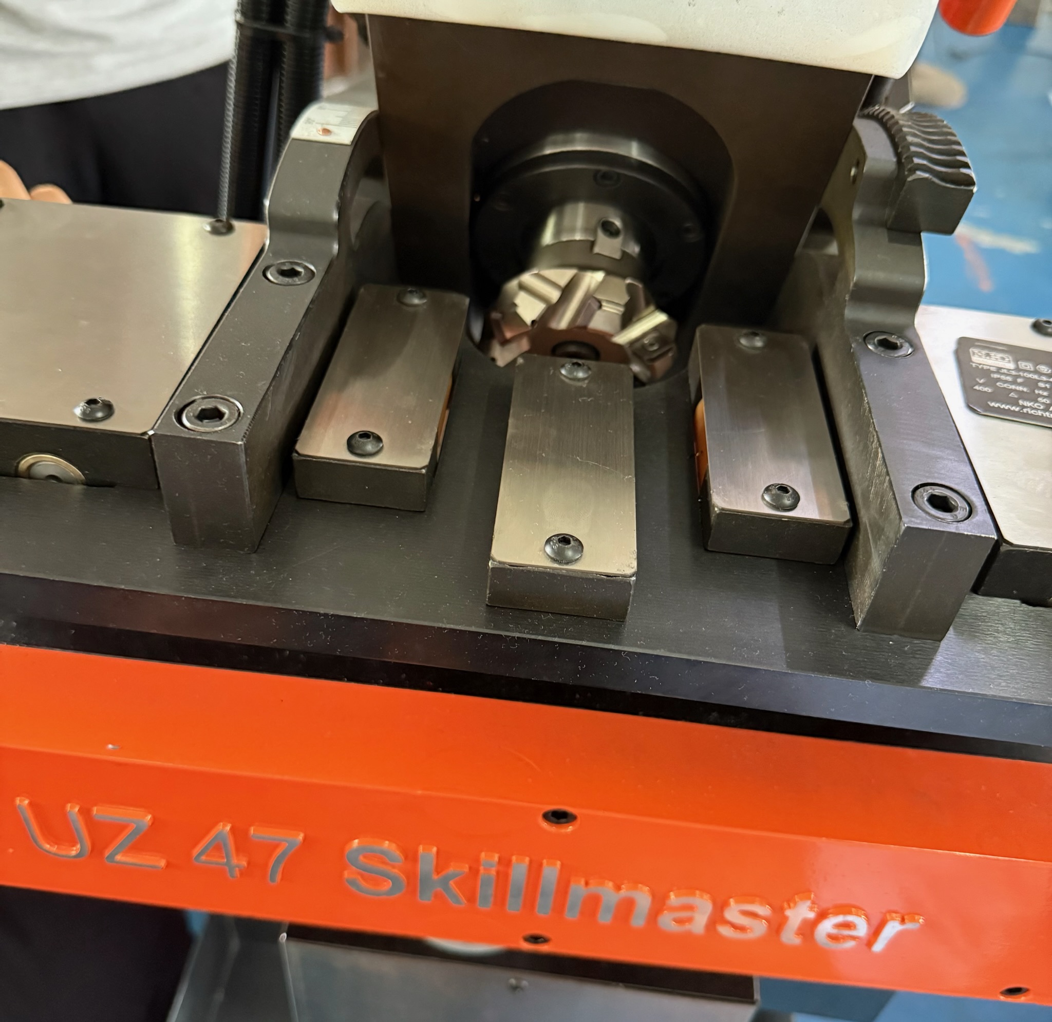 Lähivõte UZ 47 Skillmaster faasimasinast, mis näitab tööriista hoidikut ja detaili kinnitussüsteemi.