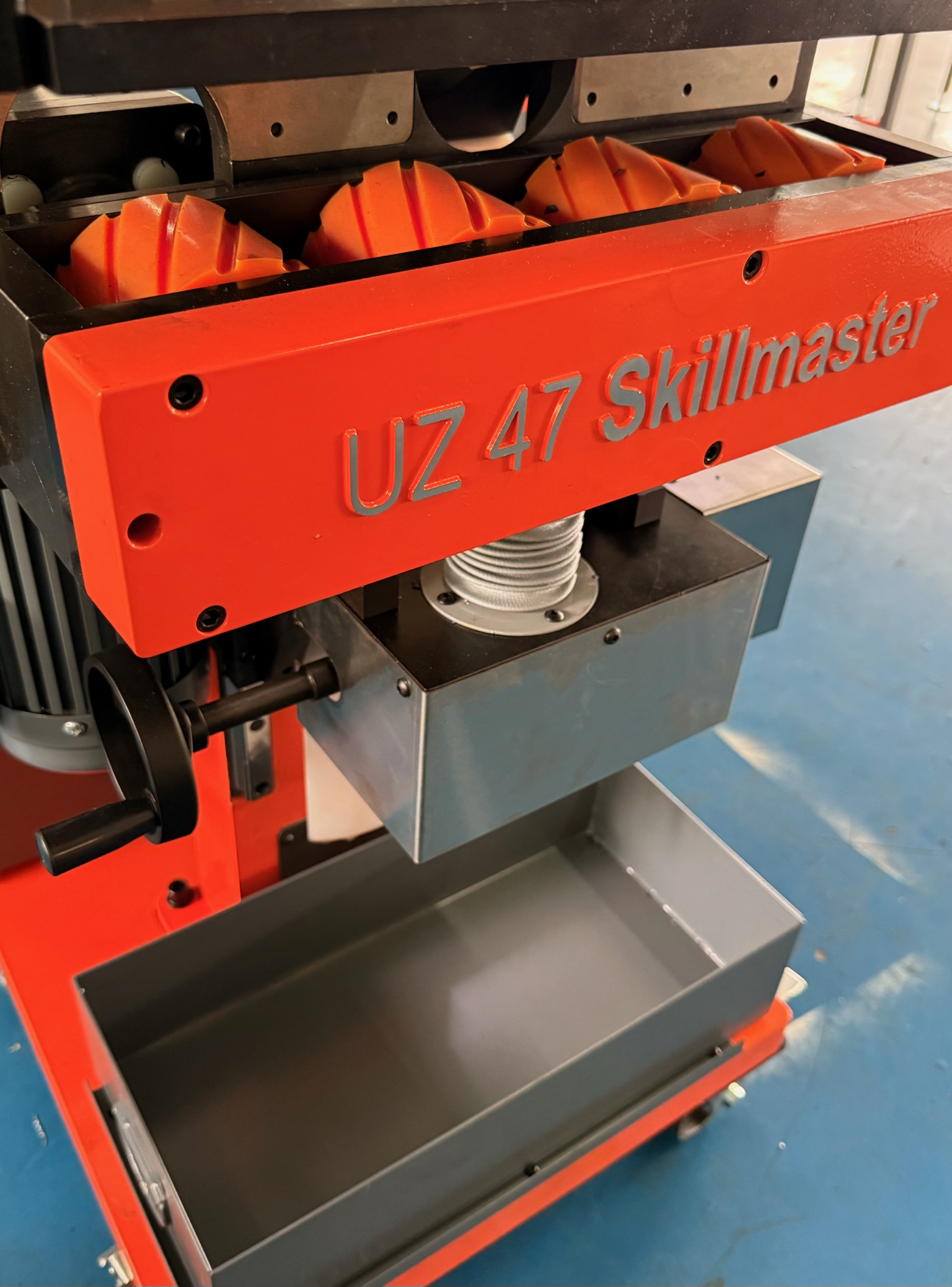 UZ 47 Skillmaster faasimasina  detailvaade, mis näitab oranže rulle ja reguleeritavaid komponente.